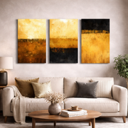 Gold and black abstract triptych canvas art hanging above sofa in a stylish living room — modern decorative wall art.