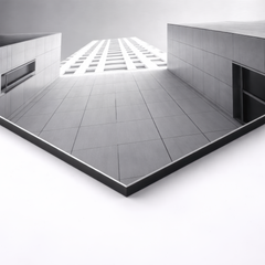 Close-up angled view of black and white architectural aluminum print showing sharp lines and urban symmetry, premium gallery style wall art
