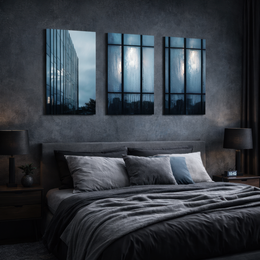 Triptych architectural photography in blue hues above modern bed, reflective glass facade artwork creating serene and refined bedroom atmosphere