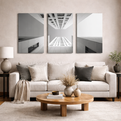 Three panel black and white building photography wall art above neutral sofa in modern living room, museum quality aluminum print for elegant home decor