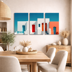 Three panel minimalist Greek island architecture wall art above beige sofa in warm neutral sitting room, vibrant blue and coral accents balancing soft interior tones