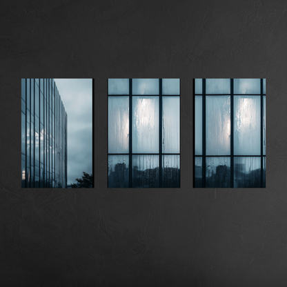 Modern three panel glass building wall art in cool blue palette, floating aluminum prints on charcoal wall creating sophisticated interior focal point