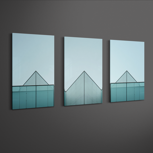 Angled perspective view of three panel architectural glass structure artwork showing pyramid roof lines and soft blue gradients