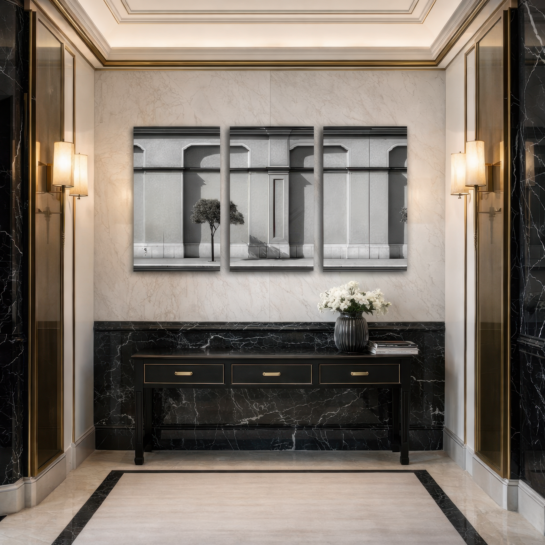 Three panel black and white architectural facade wall art installed in luxury marble hallway with brass wall sconces and black console table