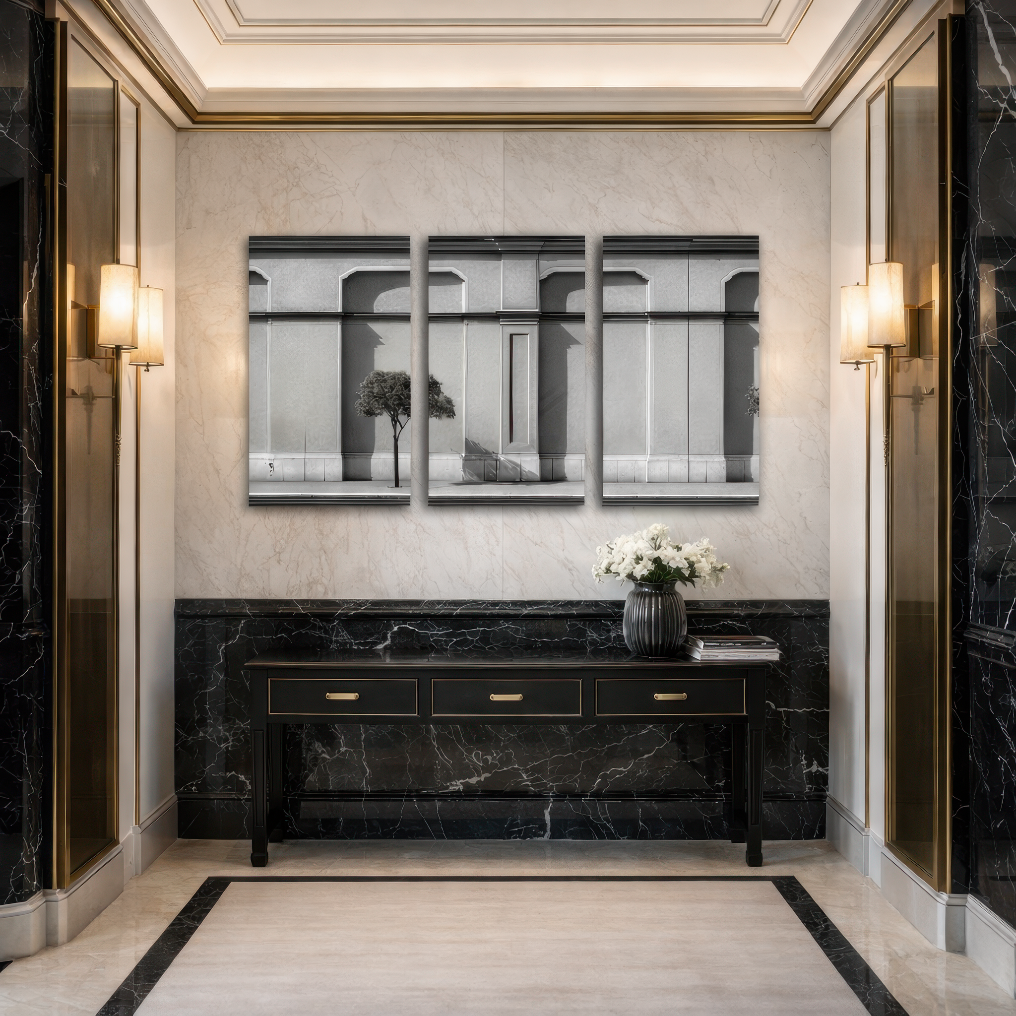 Three panel black and white architectural facade wall art installed in luxury marble hallway with brass wall sconces and black console table